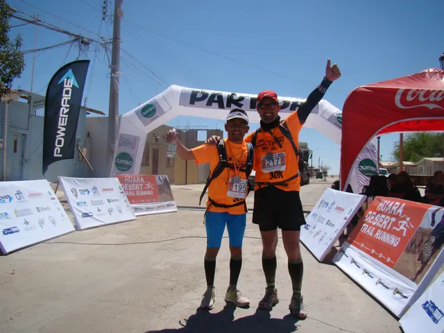Dos participantes con poleras naranjas juntos bajo el arco de Huara Desert 2015.