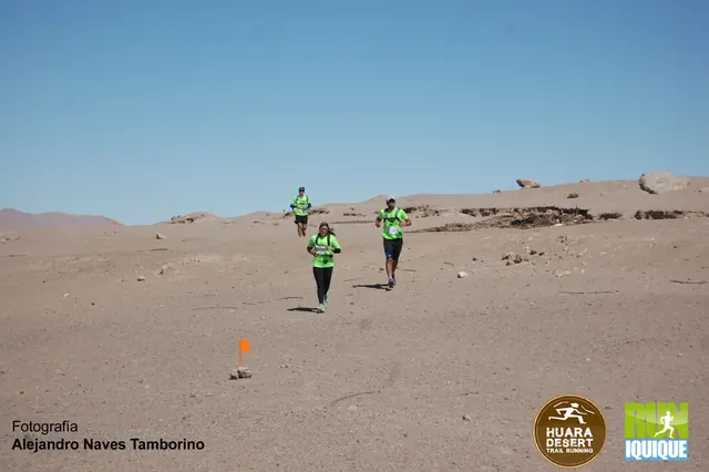 Corredores con poleras verdes en una ruta de tierra del desierto durante Huara Desert 2016.