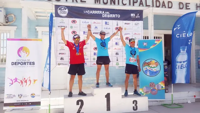 Participantes sobre el podio, frente al fondo gráfico de Huara Desert 2018.